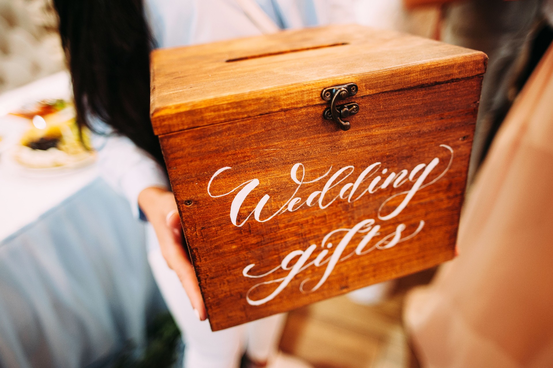 Wedding gifts. Bridesmaid holds wooden box with a handwritten sign. Present box for marriage.